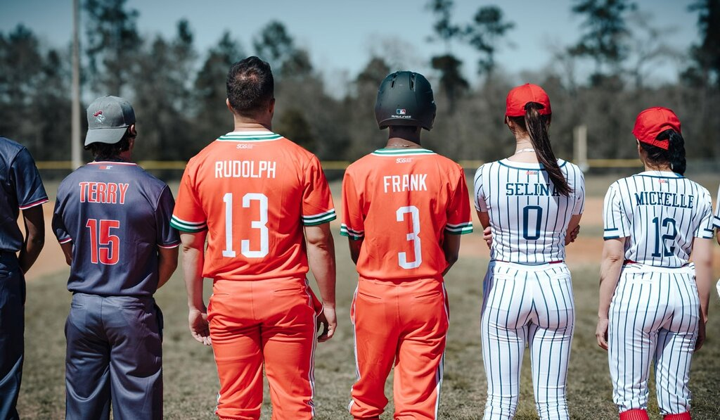Baseball players wearing custom orange and pinstripe team jerseys