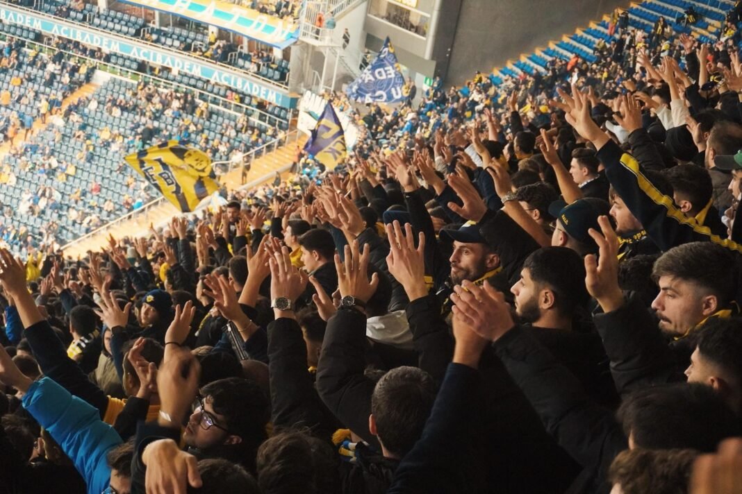 How Discreet Nicotine Ended The Smoke Break Hassle Energetic fans with raised hands in a stadium.